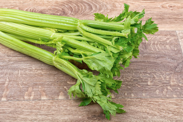 The green leaves of celery on a wooden background