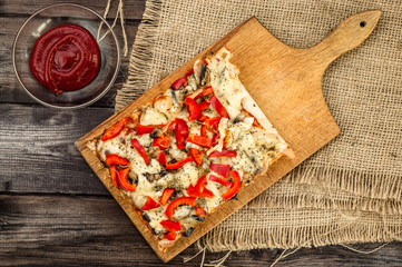 Portion of pizza on wooden background.