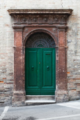 Fototapeta na wymiar Green wooden door with arch and decoration