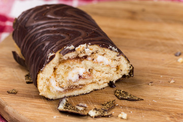 Sliced chocolate roll cake on the wooden board