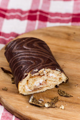 Sliced chocolate roll cake on the wooden board