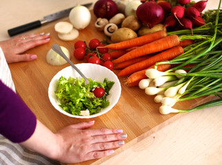 Young woman cutting vegetables in the kitchen