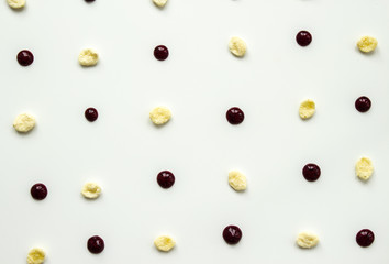 Pattern flakes and dots of black currant jam on a light background