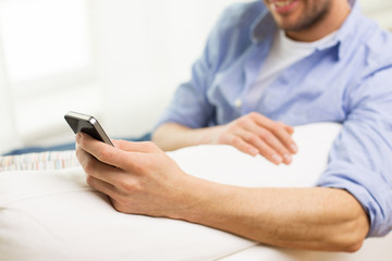 close up of man with smartphone at home