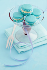 Turquoise macarons with buttercream filling on a cake stand