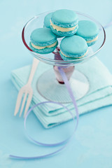 Fototapeta na wymiar Turquoise macarons with buttercream filling on a cake stand