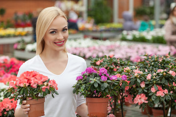 Beautiful young woman is buying preppy plant