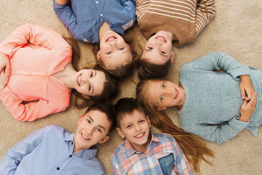 happy smiling children lying on floor in circle