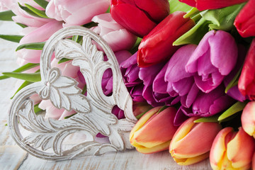 Bunch of tulips with wooden heart