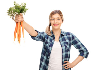 Female farmer holding a bunch of carrots