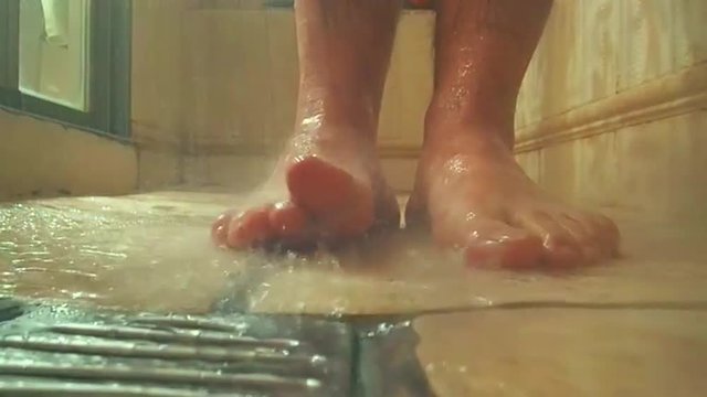 man feet while taking a shower