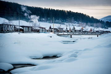 Early morning in a mountain village in Russia.Frozen river in winter wonderland