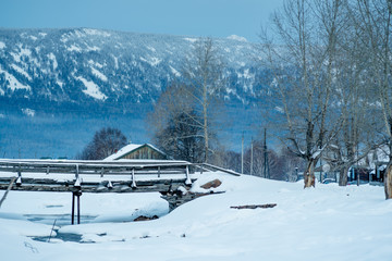 Early morning in a mountain village in Russia.Frozen river in winter wonderland