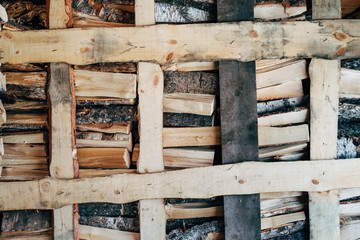 Stack of wood. Birch firewood. Old gray wooden background