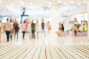 Wood floor with blurred people in shopping mall for background
