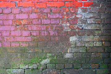 Weathered brick wall painted in pink and green color 