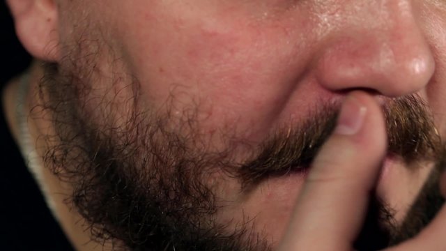 A man smoothes his mustache
