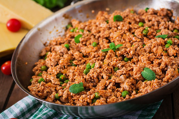 Minced meat in a frying pan for stuffing lasagna.