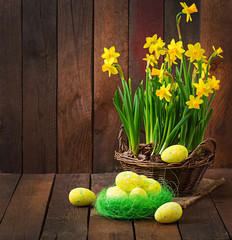 Obraz na płótnie Canvas Easter eggs and flowers on a dark wooden background