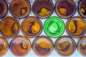 Grüne Bierflasche zwischen braunen Bierflaschen