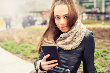 Obraz premium Beautiful woman using tablet computer on the street