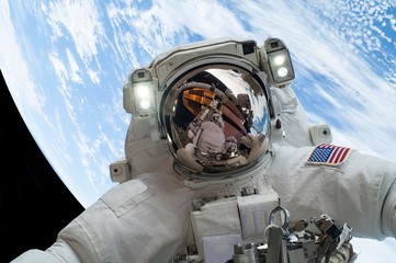 astronaut floating in space against the backdrop of earth (some elements courtesy of nasa).