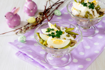 Salad with chicken and green peas on a white wooden table