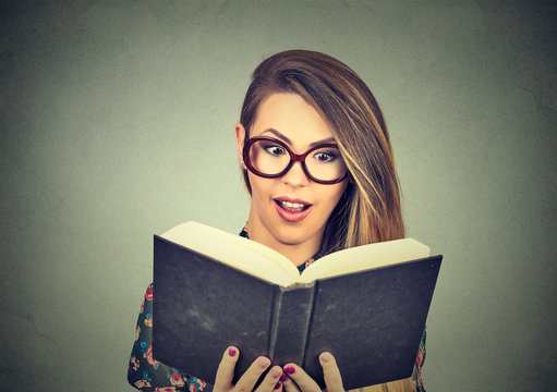 young woman in glasses reading big book