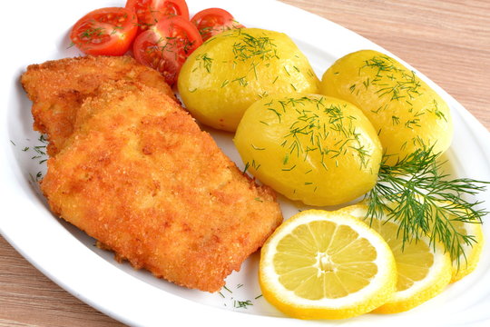 ryba smażona z ziemniakami i pomidorem