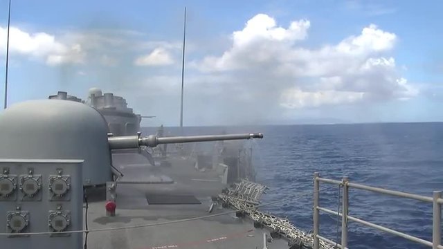 A U.S. Navy warship fires its guns.