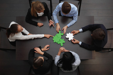 Business people assembling puzzle