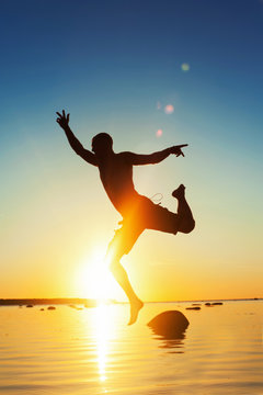 Beautiful moments of life. Funny jumping man silhouette. Sunset
