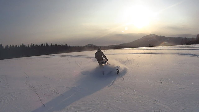 Athlete on a snowmobile moving in the winter forest in the mountains of the Southern Urals.