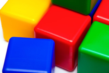 Red, blue, yellow and green plastic blocks on white background.