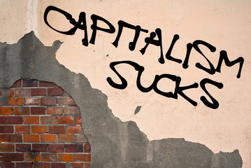CAPITALISM SUCKS text sprayed on the old wall, anarchist aesthetics 