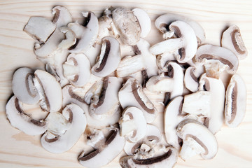 нарезка грибов шампиньонов на деревянном фоне