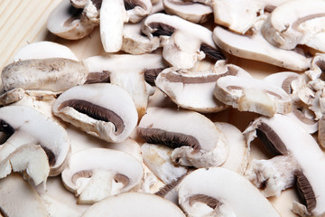 нарезка грибов шампиньонов на деревянном фоне