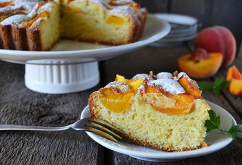 Delicate cake with peaches, dusted with icing sugar
