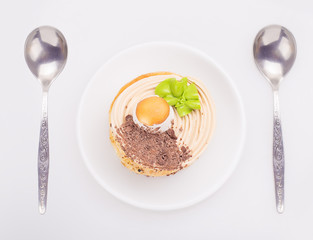 cake on a saucer with a two spoon, view from above