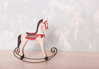 toy rocking horse on the wooden floor against the backdrop of a