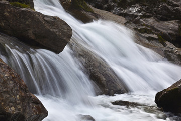 Bergbach mit kleinem Wasserfall und Bewegungsunschärfe