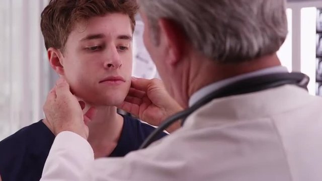 College basketball player having neck injury checked by medical doctor