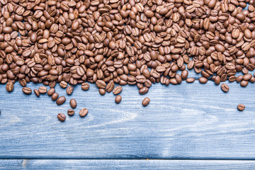 Coffee seeds on blue wood background.