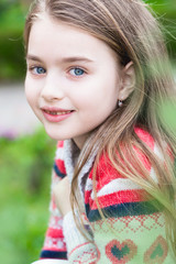 Spring fairy. Portrait of beautiful little smiling girl with brownish blond hair and blue eyes. 