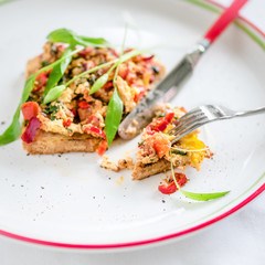 Vegetarian sandwich with scrambled eggs, tomatoes and herbs.