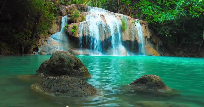 Beautiful waterfall cascade and natural pond with blue water in jungle forest