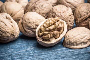 Nut shell cracked on wooden blue table.