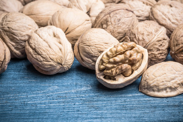 Walnuts on grunge blue wooden table.
