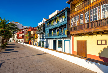 Fototapeta na wymiar Famous ancient colorful balconies decorated with flowers in Santa Cruz city on La Palma island in Spain