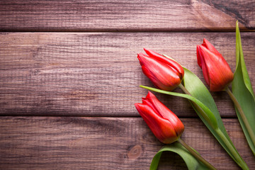 Red tulips flowers on wooden desks.